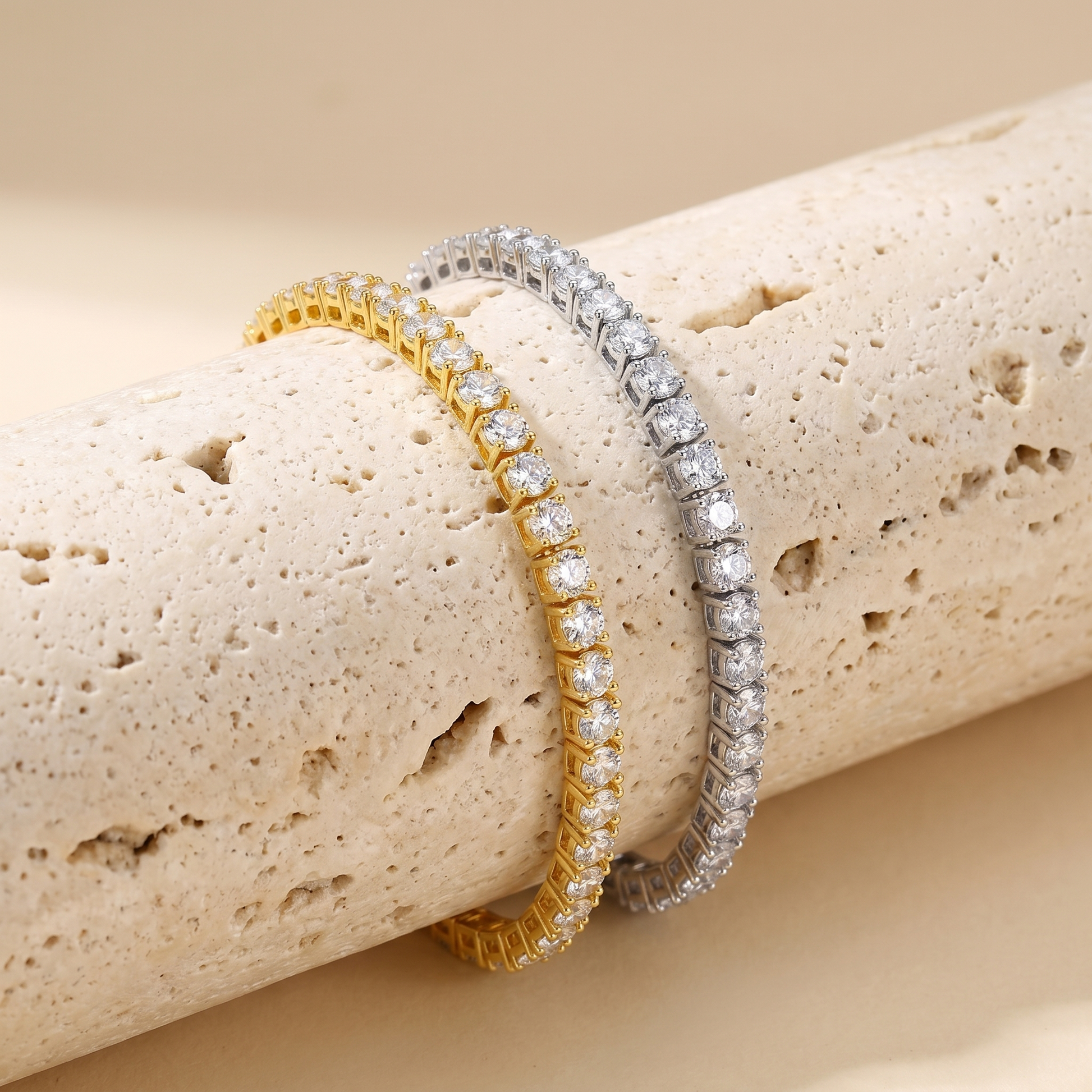 Luxury gold and silver tennis bracelets displayed on natural stone background