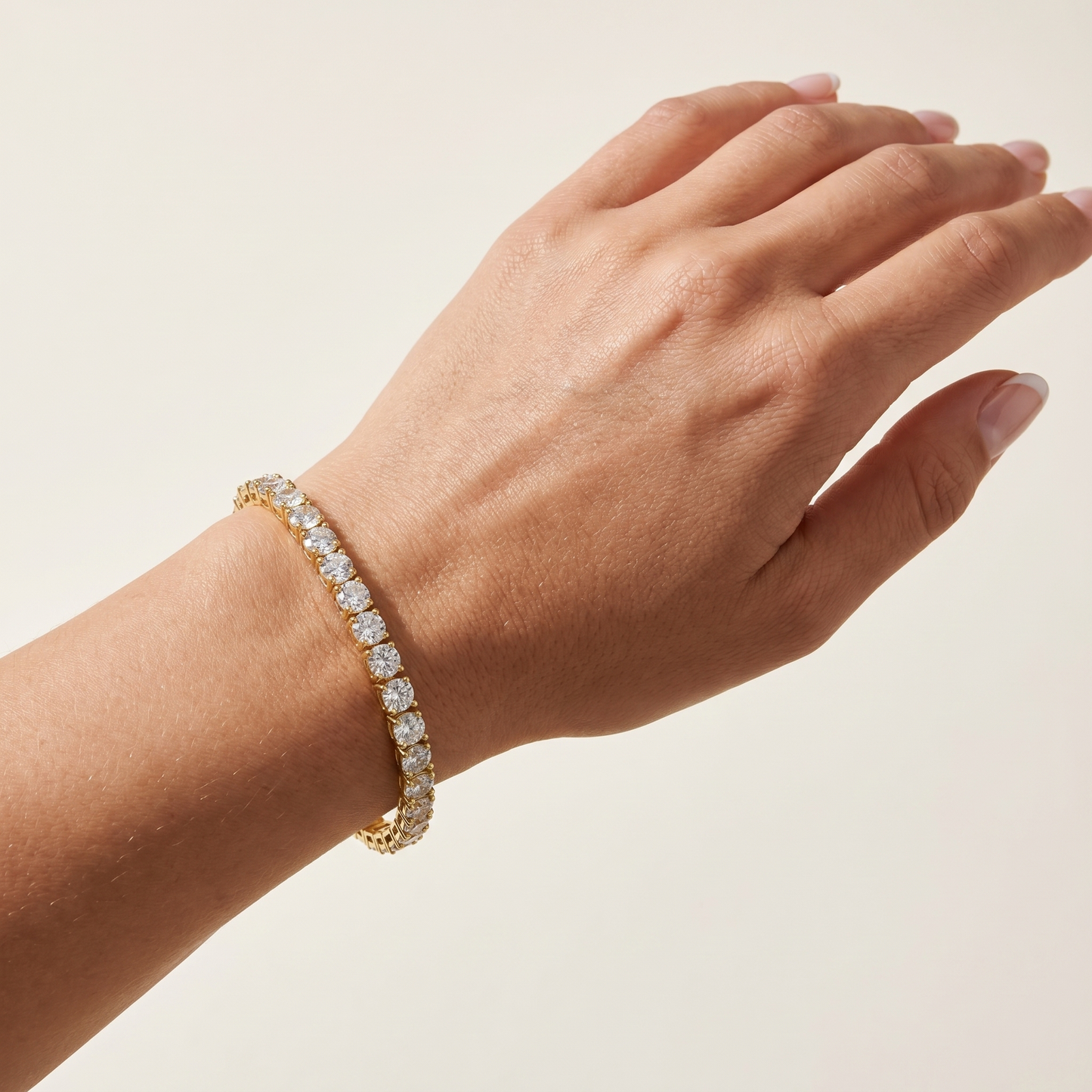 Gold plated tennis bracelet worn on wrist showing sparkle and fit